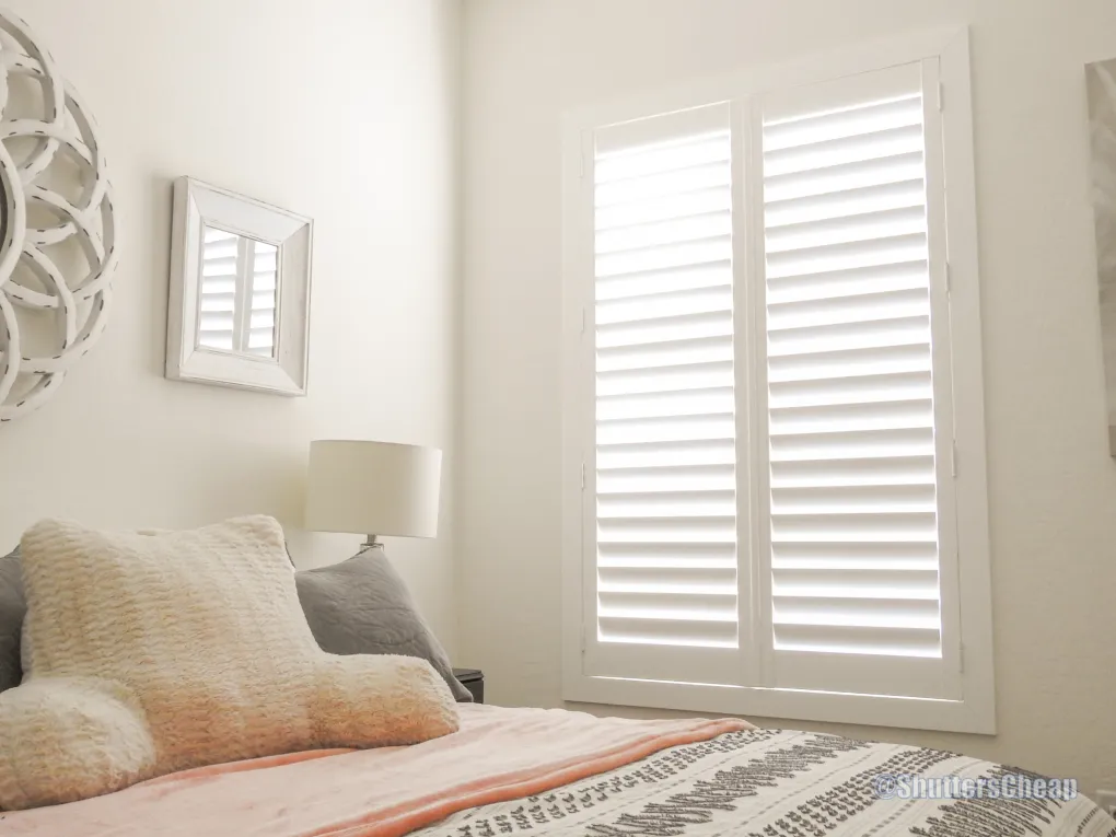 Bedroom with layered shades and shutters